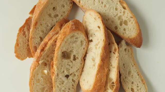 Slices of fresh bread rotating on white background