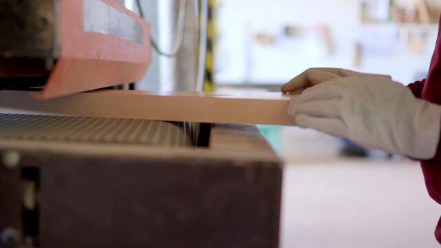 Carpenter sanding a wooden board with an industrial sander