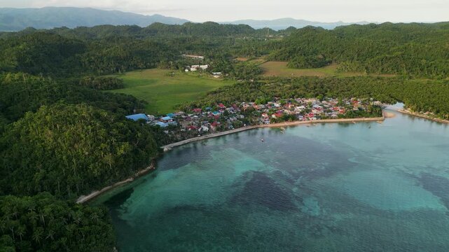 Panoramic aerial view of Magnesia Del Norte in Virac, Catanduanes with a coastal village, clear bay water, and lush tropical hills