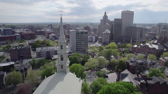 Drone aerial view of a white church tower while focusing on Providence, Rhode Island.