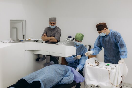 Ophthalmologists performing laser eye surgery on patient in clinic