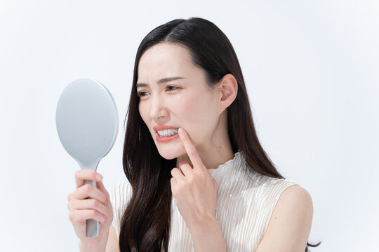 手鏡を見て肌のチェックをする女性