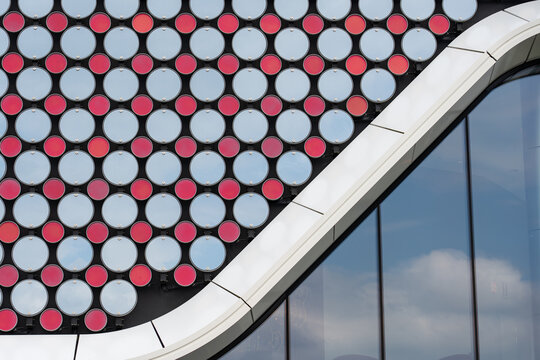 Aerial view of the modern facade of Holland Casino Venlo featuring a pattern of red and white circular elements and curved architectural lines in Venlo, Limburg, Netherlands.