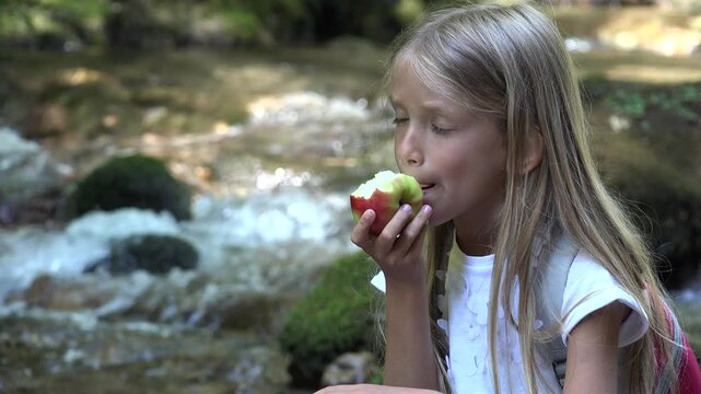 Child Eating Apples by River, Camping Mountains View, Girl Eats Fresh Fruits Outdoor in Nature