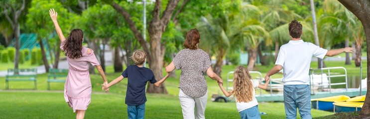 Fototapeta premium Happiness family outdoor joyful enjoying nature bonding in nature intergenerational happiness. Multigenerational family walking in park outdoor fun lifestyle relaxing smiling walking connection