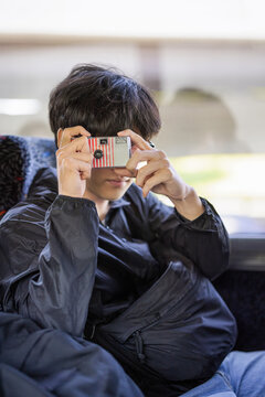 Male Traveler Using Disposable Camera on Tourist Bus