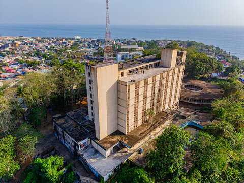 Aerial view of the abandoned Ducor Intercontinental Hotel and a radio tower overlooking the cityscape and Atlantic Ocean in Monrovia, Montserrado, Liberia.