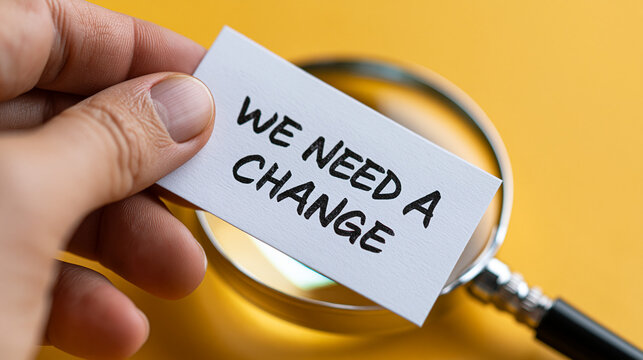 A hand holding a card with a message about needing change and a magnifying glass