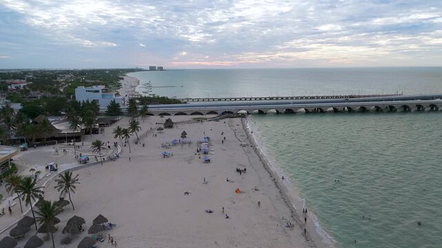 High Aerial View of Arched Viaduct Pier and Beachfront at Sunset in Progreso Yucatan, Mexico. Aerial landscape shot captures the scenic coastline and engineering structures of Progreso.