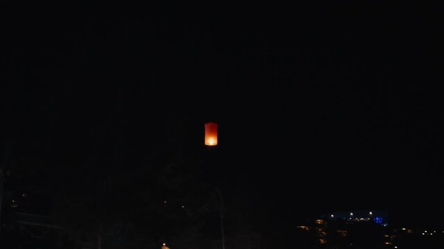 Floating sky lantern flying into the night sky