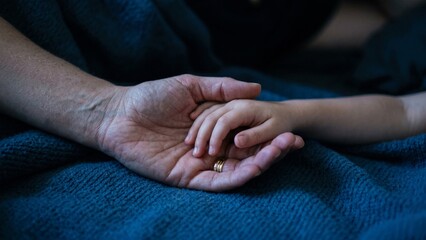 Fototapeta premium Hand of Mother Gently Holding Her Childs Hand Showing Connection and Love