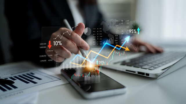 A business professional reviews financial data utilizing a smartphone and laptop in a modern office. Charts and graphs display insights on performance and growth trends. Scalp