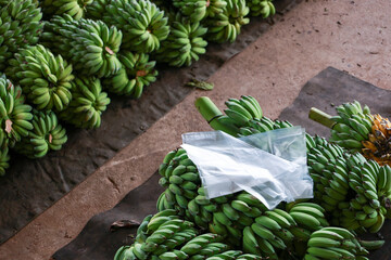 Abundant fresh green unripe banana bunches on display at an outdoor market. tropical fruit food showing natural bumpy texture, plentiful and organic harvest for sale © CoreRock