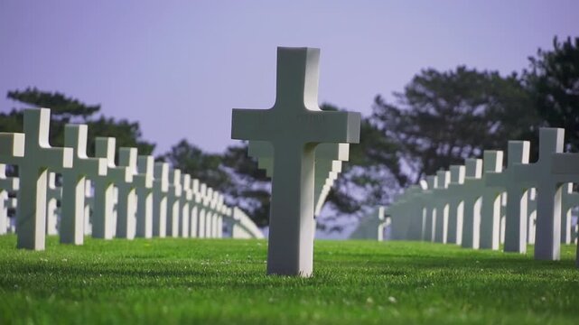 American memorial cemetery with military grave markers aligned on green lawn. Memorial Day and remembrance of soldiers killed in war