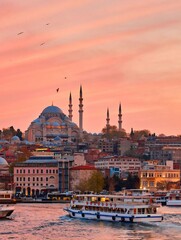 Naklejka premium Beautiful sunset over Istanbul with Suleymaniye Mosque and ferry boat on the Golden Horn, Turkey
