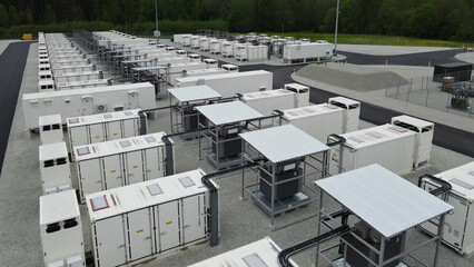 Large scale battery storage containers at a power plant, providing energy storage for grid modernization and sustainable energy © Dark Artistic