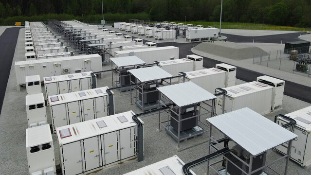 Large scale battery storage containers at a power plant, providing energy storage for grid modernization and sustainable energy