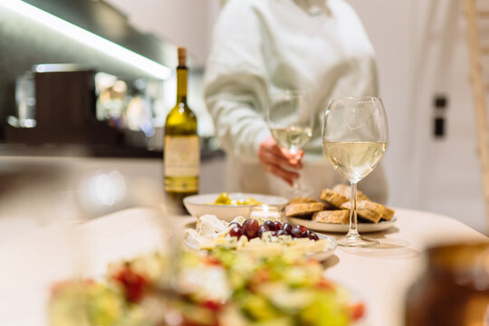 Romantic dinner table with white wine and appetizers inside cozy rental cabin