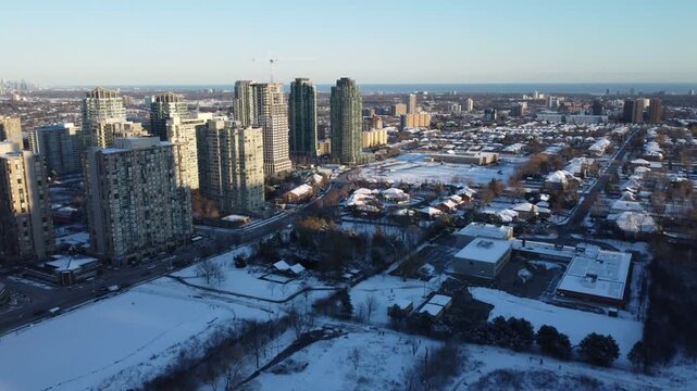 Aerial shot flying south over Mississauga, Ontario, Canada from city centre downtown Square One area towards Lake Ontario during a cold, sunny winter December day in 2021.