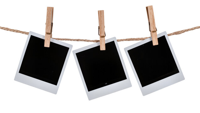 Three blank instant photo prints hanging on a rope with wooden clothespins, isolated on transparent background