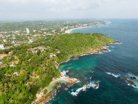 Aerial view of Secret Beach Mirissa with turquoise ocean water, rocky shoreline, and lush tropical greenery Mirissa, Southern Province, Sri Lanka.