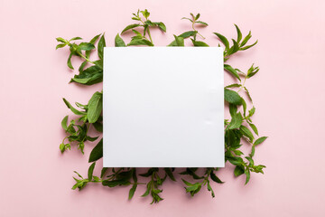 Wreath frame made of empty paper blank with space for text and mint leaves on colored background. . Mint Pattern. Flat lay. Top view © sosiukin