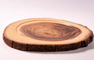 Obraz premium Natural wooden cutting board made from a tree slice isolated on a white background. ideal for kitchen, food presentation, and handcrafted product concepts.