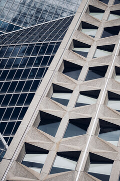 Structural facade architecture crosses glass windows with concrete pattern, turning an urban building into a geometric lattice under daylight