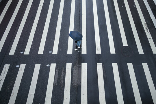 Person with umbrella walking on crosswalk, Taipei, Taiwan