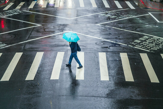 Person with umbrella walking on crosswalk, Taipei, Taiwan