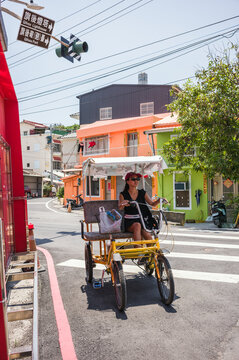 Asian woman on a rickshaw in the street of Cijin, Kaohsiung, Taiwan
