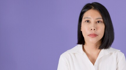 Fototapeta premium Pensive Asian Woman with Short Hair Looking Away on Purple Background