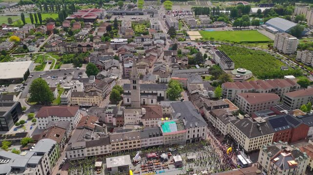 Cinematic drone footage flying above the alpine town of Martigny in Valais, Switzerland, featuring mountain scenery, vineyards, historic architecture and beautiful Swiss valley landscapes on a sunny d