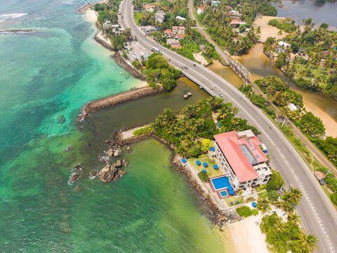 Aerial view of Devil's Rock and the scenic coastline with a winding road and lush tropical vegetation in Ahangama, Southern Province, Sri Lanka.