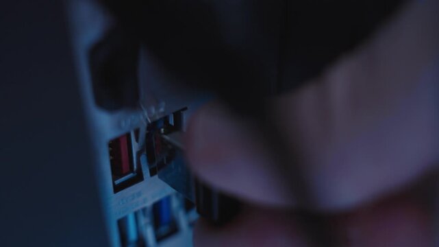 Extreme close up hand inserting thumb drive into desktop computer or server. Conspiracy stealing information and secret data or installing spyware by hacker or spy in government devices. Hidden tech