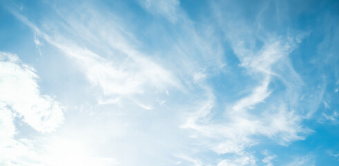 Obraz premium the sky is clear blue with fluffy white clouds, the sky is very bright, and the sun shines.