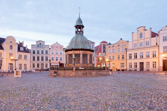 Germany, Wismar, market square with Wasserkunst at twilight