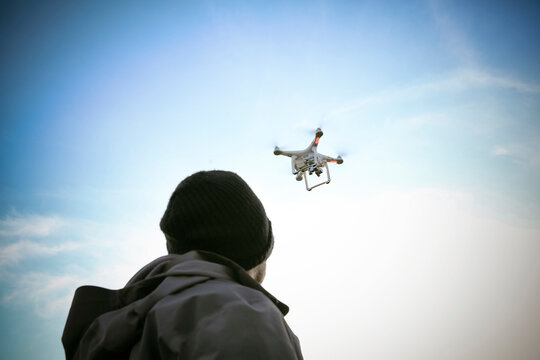 Back view of man flying drone