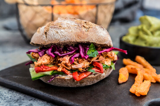 Vegan jackfruit burger with sweet potato fries and guacamole