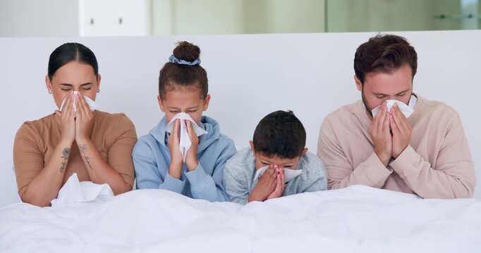 Sick, family and blowing nose with tissue in bed for influenza, virus or infection together in home. Mom, dad and children in blanket with hayfever, sinus or allergies for flu, cold or germs in house