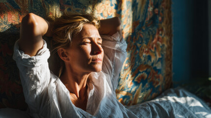 Obraz premium Woman stretching in bed during morning light in cozy bedroom with colorful tapestry hanging on wall