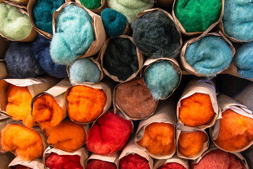 Rolled colorful wool fleece stored in paper tubes at artisan textile workshop © were