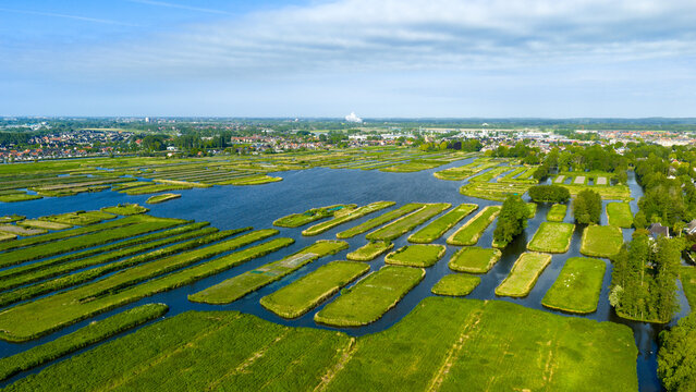 Aerial view of the Oosterdel nature reserve with its unique thousand islands landscape and lush green fields in Broek op Langedijk, Noord-Holland, Netherlands.
