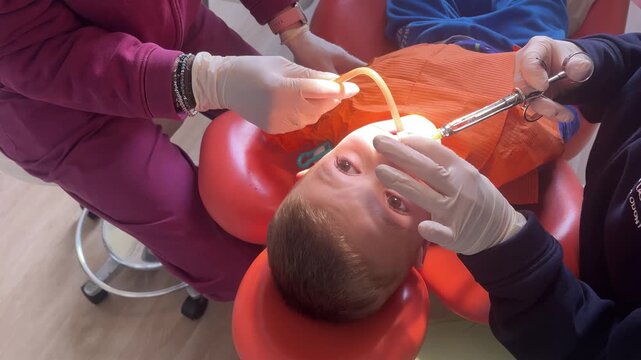 video of boy undergoing dental treatment with local anesthesia, mouth rinsing in dental clinic.kindness,attentive care provided by caring dental professionals dedicated to children&rsquo;s oral well-being