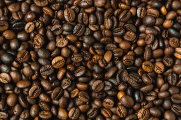 Fototapeta premium Close-up view of roasted coffee beans with rich brown tones and detailed texture, top down