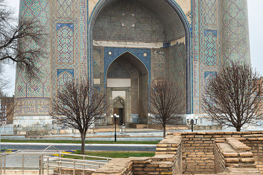 Bibi-Khanym Mosque entrance portal with turquoise tilework in Samarkand during early spring. Monumental Islamic architecture ideal for travel publications and heritage content.