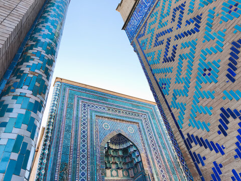 Shah-i-Zinda necropolis facades with intricate blue tilework in Samarkand, Uzbekistan. Ideal for travel publications, cultural heritage content, and architectural design inspiration.