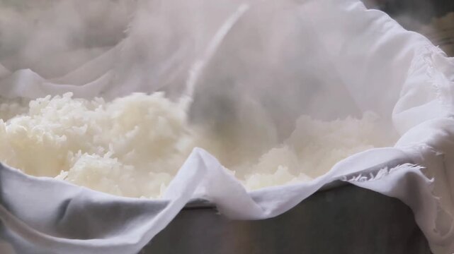 Freshly steamed glutinous rice in a traditional bamboo basket, representing agricultural product and economic crop as asian staple food