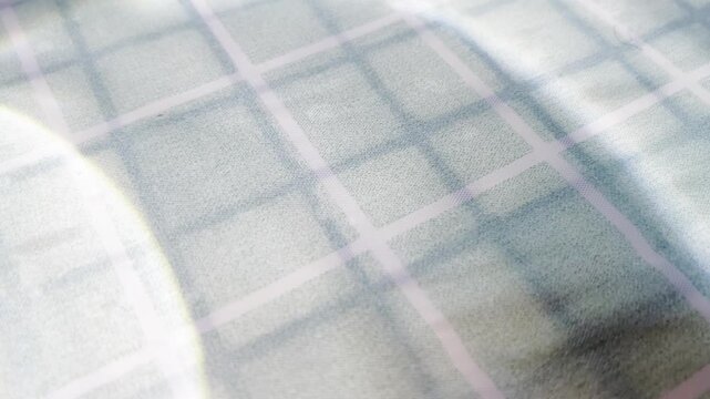 Playful sunlight reflections creating caustic patterns and light refraction dancing on a textured grid surface with gentle, shimmering movement for a relaxing background