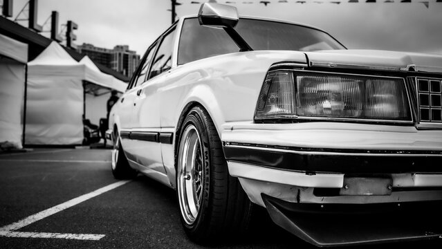 Kyiv, Ukraine - October 20, 2023. Black and white view of a lowered vintage car displayed outdoors at Kyiv Car Fest, an automotive event featuring classic, custom and collector vehicles.